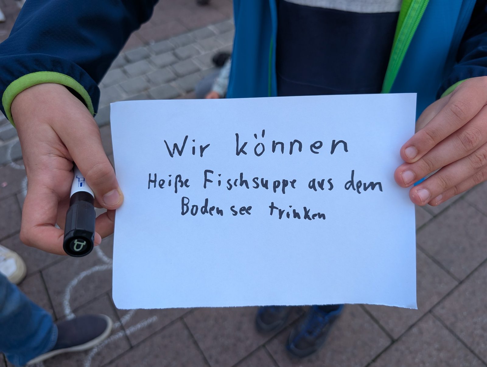 Handgeschriebenes Schild: „Wir können heiße Fischsuppe aus dem Bodensee trinken”.