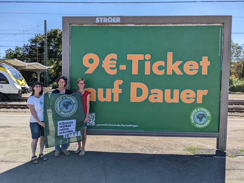 Parents für Future Tübingen und Reutlingen fordern mit Großplakaten an den Bahnsteigen in Reutlingen und Tübingen ein 9-Euro-Ticket auf Dauer und einen schnellen und umfassenden Ausbau des ÖPNV. Die Anstrengungen zum Klimaschutz müssen genauso drastisch sein, wie die derzeitigen katastrophalen Auswirkungen der Klimakrise wie Dürren und Starkregen, so Verena Ludewig von Parents for Future Reutlingen. Nur mit solchen drastischen Maßnahmen können wir unser Leben auf unserem Planeten in Zukunft sicherstellen, ist Tanja Leinweber von Parents für Future Tübingen überzeugt. Ein 9-Euro-Ticket ist hierfür noch eine der kleineren Maßnahmen. Die gesamte Bevölkerung wird zudem auf diesem für uns alle schwierigen Weg zur Bewältigung der Klimakrise mitgenommen. Die Voraussetzungen dafür sind gegeben. Mehr als drei Viertel der Menschen wohnen in Deutschland in einer Stadt. Doch ist der ÖPNV noch nicht ausreichend attraktiv. Es werden selbst in der Stadt mehr als 30 Prozent der täglichen Kilometer mit dem PKW zurückgelegt. Mit dem 9-Euro-Ticket wird die Nutzung des ÖPNV viel einfacher. Der Dschungel aus Verbundgrenzen und Tarifen fällt – auch für einzelne Fahrten - weg. Das 9-Euro-Ticket auf Dauer würde schnell einen hohen Beitrag zum Klimaschutz erbringen, wie mehrere Studien belegen Regine Gut von Parents for Future Tübingen ergänzt, dass parallel unbedingt ein massiver Ausbau des ÖPNV erforderlich ist. Dies ist ebenso wichtig wie das 9-Euro-Ticket selbst, um den ÖPNV insgesamt attraktiver und leistungsfähiger zu machen, auch im ländlichen Raum.