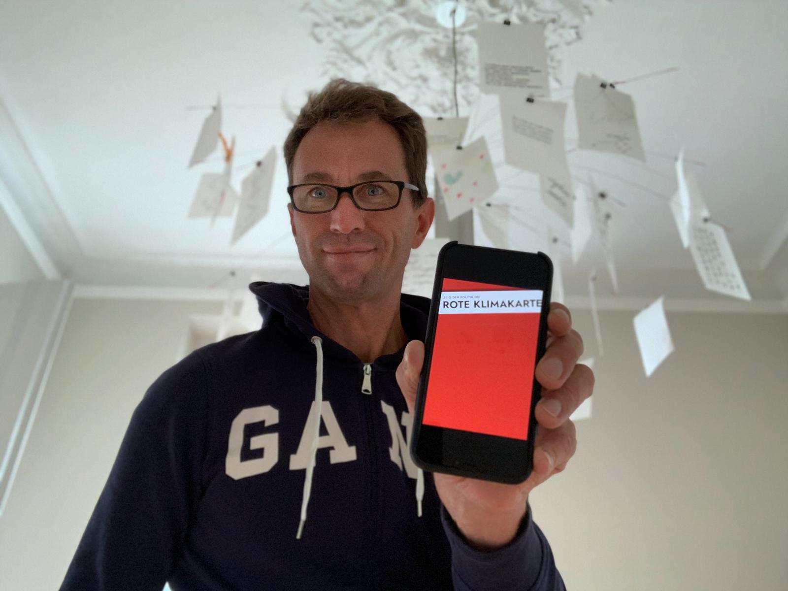 Mensch zeigt Handy mit roter Karte im Display