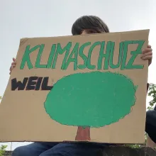 Junge mit Klimaschutz-Plakat